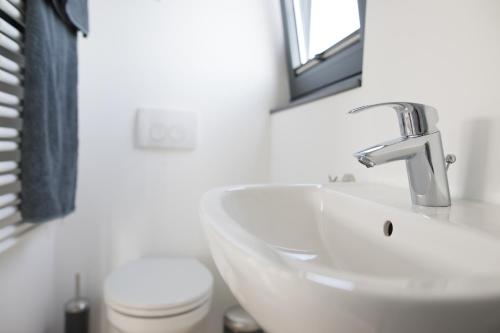 een witte badkamer met een wastafel en een toilet bij Hausboot WELL - Husbåd WELL in Egernsund