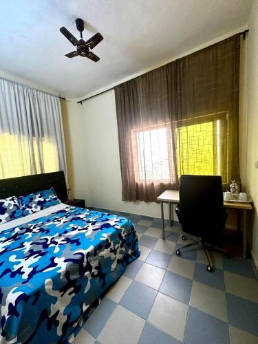 a bedroom with a bed and a desk and a ceiling fan at Private Room In Cotonou Home in Cotonou