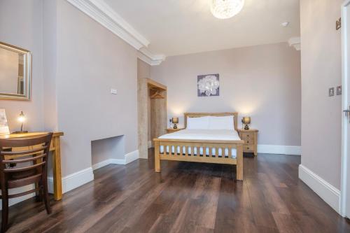 a bedroom with a bed and a wooden floor at Marlborough Hotel in Norwich