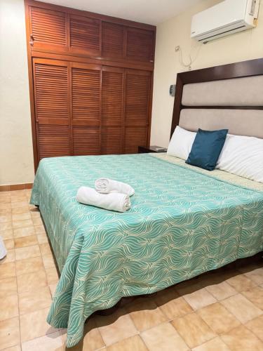 um quarto com uma cama com duas toalhas em La Casita de Jonas em Puerto Morelos