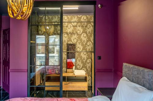 um quarto com paredes roxas e uma caixa de vidro em Apartments center em Lárissa
