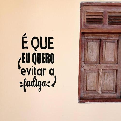 a wall with a door and a quote on it at Vila do Chaves in Itaúnas
