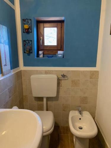 a bathroom with a toilet and a sink and a window at [Stanza Lavanda] in Varzi