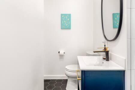 uma casa de banho com um WC, um lavatório e um espelho. em Vibe on the Patio at a Modern Luxury Studio near LAX Beach em Los Angeles