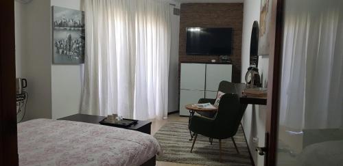 a hotel room with a bed and a desk with a chair at Sunshine Court in St Paul's Bay
