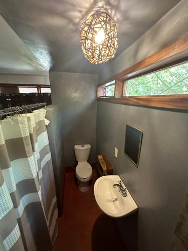 uma casa de banho com um lavatório, um WC e um lustre em Casa AVA em Mazunte