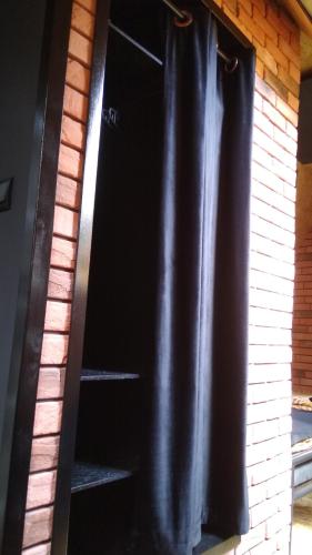 a black shower curtain hanging on a brick wall at Zaciszny Zakątek Zawoja in Zawoja