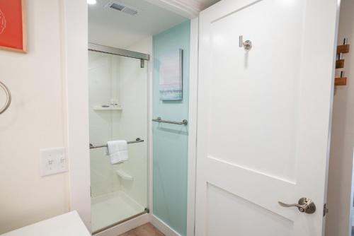 a bathroom with a shower and a glass door at Manasota Key Resort in Englewood