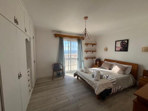 a bedroom with a bed and a large window at villa com piscina entre o mar e as montanhas in Paul do Mar