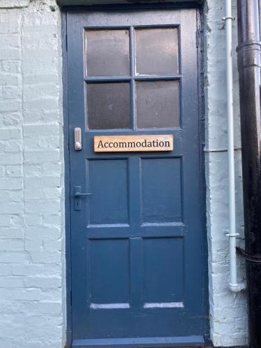 une porte bleue avec un panneau indiquant l'association dans l'établissement Pershore Rooms at The Star, à Pershore