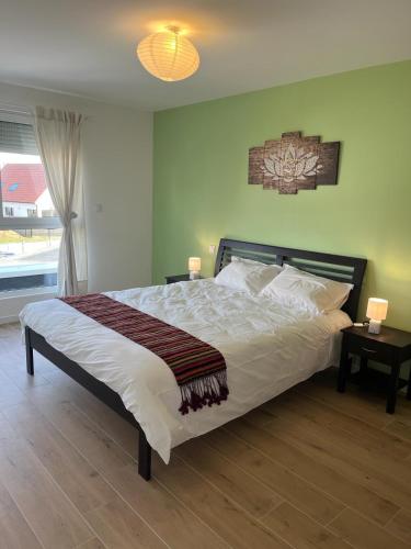 une chambre avec un grand lit avec un plancher en bois dans l'établissement La Perle du petit Rupembert, à Wimille