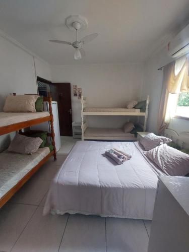 a bedroom with two bunk beds and a ceiling fan at Pousada Nascimentos in Bertioga