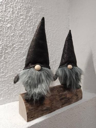 two gnome figurines sitting on a piece of wood at Zaciszny Zakątek Zawoja in Zawoja