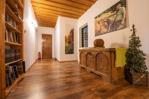 a living room with a wooden floor and bookshelves at Biobauernhof Lacken in Strohmarkt