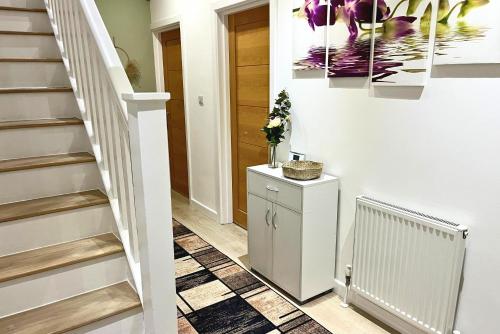 a staircase in a home with a white wall at Modern and Spacious 3 Bed House, Sleeps 5, Close to Southampton City Centre, in Southampton