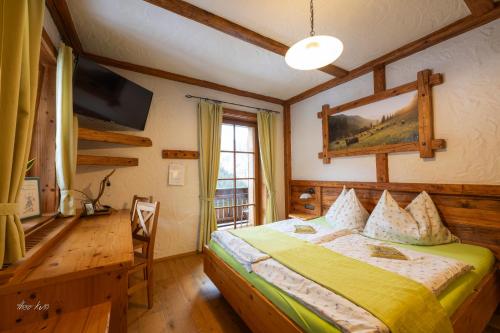 a bedroom with a bed and a desk and a television at Biobauernhof Lacken in Strohmarkt