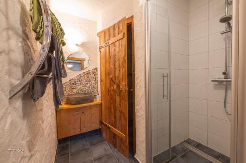 a bathroom with a shower and a wooden door at Biobauernhof Lacken in Strohmarkt