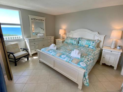 a bedroom with a bed and a chair and a mirror at EBT 302b in Fort Myers Beach