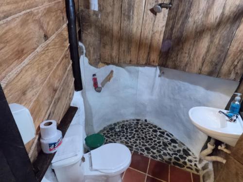een badkamer met een vloer met luipaardprint, een toilet en een wastafel bij Cabaña Eco-Río Cristalino/Hamacas/Fogata in San Francisco