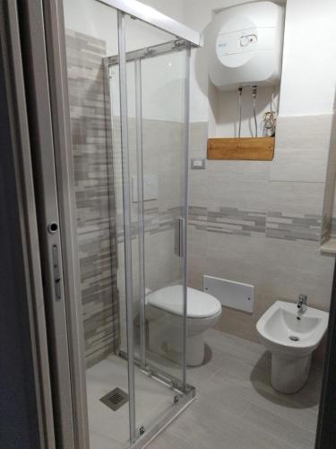 een badkamer met een toilet en een glazen douche bij Dimora del Malconsiglio in Miglionico
