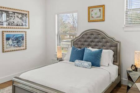 a white bedroom with a large bed with blue pillows at The O'Keeffe-2nd Floor Boutique Hotel Suite in Bentonville