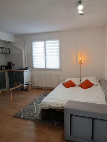 - une chambre avec un lit et deux oreillers orange dans l'établissement Élégant T2 proche hypercentre, à Toulouse