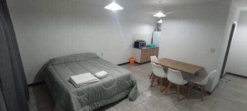a bedroom with a bed and a table and chairs at Home Alojamientos Temporales in San Luis