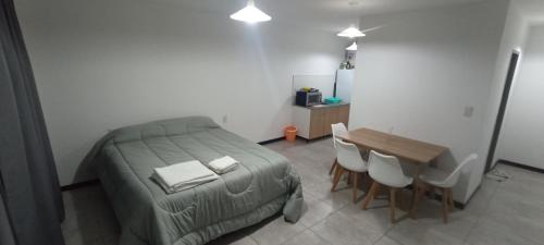 Un dormitorio con una cama y una mesa y sillas. en Home Alojamientos Temporales, en San Luis