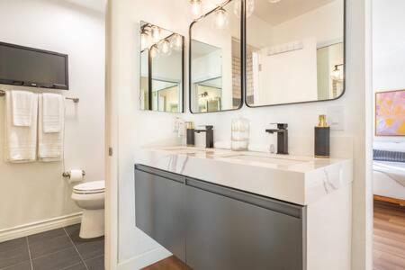 Baño blanco con 2 lavabos y aseo en Spectacular Ocean and Pier View Lux Family Vacation, en Manhattan Beach