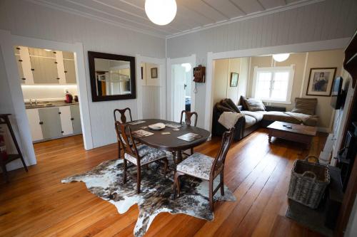 - un salon avec une table, des chaises et un canapé dans l'établissement The Farmhouse Kaeo Whangaroa, à Kaeo