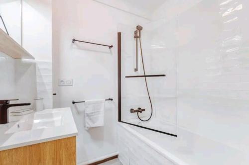 une salle de bain blanche avec une douche et un lavabo dans l'établissement Bel Appartement - 3 chambres - Proche Gare St Roch, à Montpellier