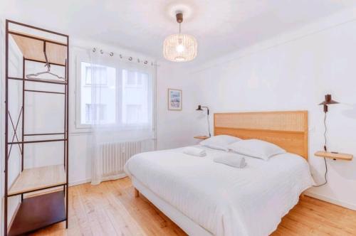 une chambre blanche avec un grand lit et une fenêtre dans l'établissement Bel Appartement - 3 chambres - Proche Gare St Roch, à Montpellier