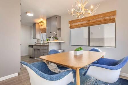 a dining room with a table and blue chairs at Downtown Manhattan Beach 3 Bed Townhouse Parking in Manhattan Beach