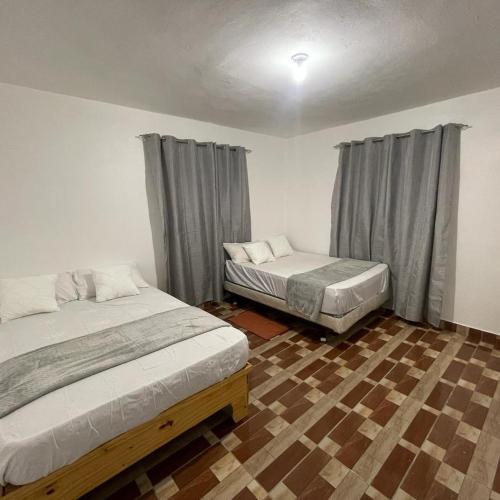a bedroom with two beds and a checkered floor at Villa Hermanos Luciano 