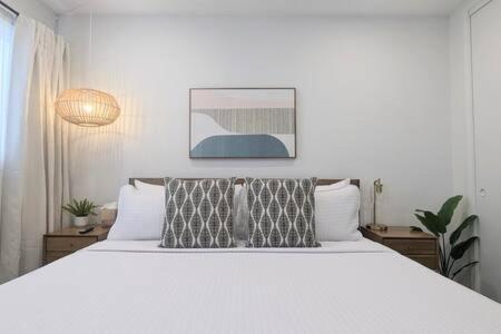 マンハッタン・ビーチにあるOcean View 1 Bedroom Manhattan Beachの大きな白いベッドと枕が2つある寝室