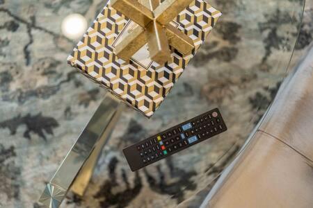 a remote control and a box on a table at The Warhol - Pet-Friendly Apartment in Bentonville