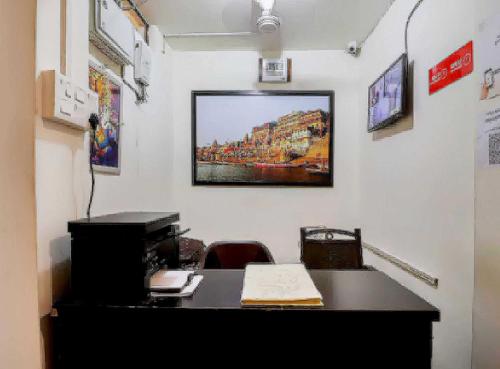 una oficina con un escritorio con un monitor en la pared en Golden Cafe en Chennai