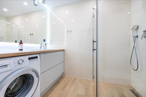 a washing machine in a bathroom with a shower at Posejdon - BillBerry Apartments in Gdańsk