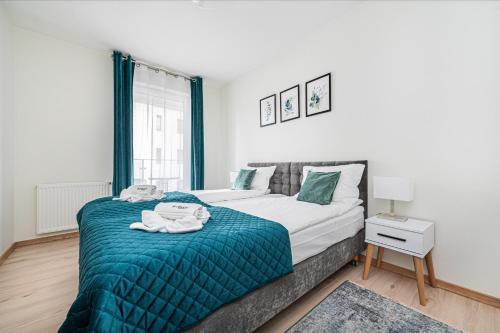 1 dormitorio con 1 cama con manta verde en Posejdon - BillBerry Apartments en Gdansk
