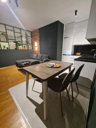 eine Küche und ein Wohnzimmer mit einem Tisch und Stühlen in der Unterkunft Apartment 2 Plisi Gjilan in Gnjilane