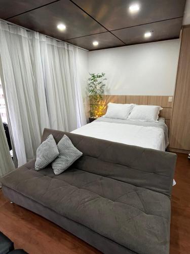 a large bed in a bedroom with a couch at Apartamento premium - Df plaza in Brasilia