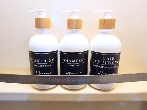four bottles of hair conditioner sitting on a shelf at 8min walk from Namba Station for 4 people gran704 in Osaka