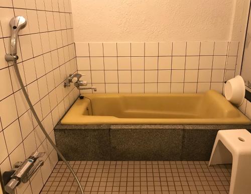 ein Bad mit grüner Badewanne in einem Zimmer in der Unterkunft Antique Villa Lotus（古民家ロータス） in Tsukuba