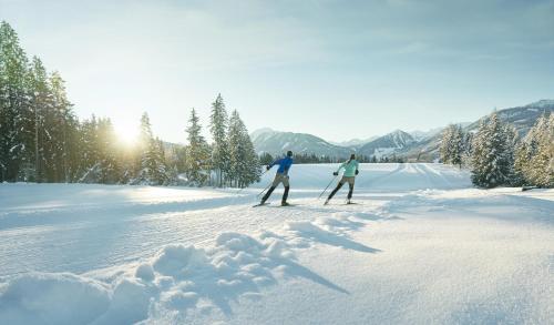 two people cross country skiing in the snow at Landhaus Wieser in Ramsau am Dachstein