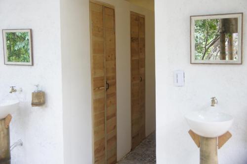 a bathroom with two sinks and a wooden door at Hostal Vista Verde Minca in Minca