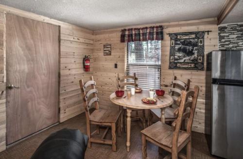 a kitchen with a table and chairs and a refrigerator at Canyon Cabins in Ruidoso