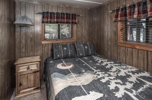 a small bedroom with a bed and a window at Canyon Cabins in Ruidoso