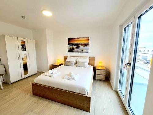 ein Schlafzimmer mit einem großen Bett und einem großen Fenster in der Unterkunft Luxurious 5 bedrooms house 