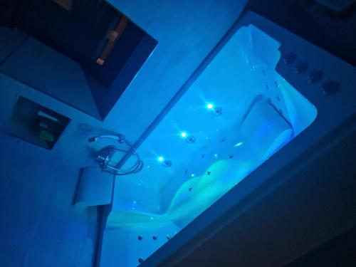 ein Bad mit einer blau beleuchteten Badewanne in einem Zimmer in der Unterkunft villa proche de coursseulles sur mer 