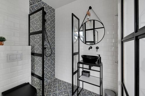 a bathroom with a black sink and a mirror at Apartament Amber by Q4 Apartments Old Town in Gdańsk